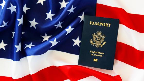 United States Flag (Red and White Stripes and White Stars) and United States Blue Passport Book on top