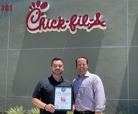 Clerk-Recorder Hugh Nguyen presenting a certificate of recognition to Chick-fil-a. 