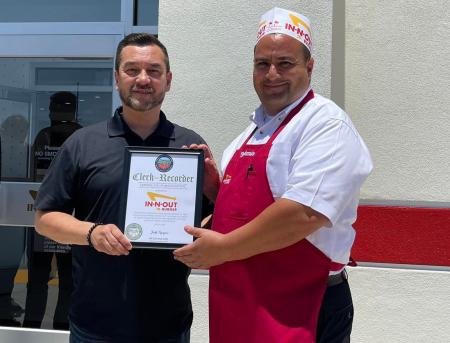 Clerk-Recorder Hugh Nguyen presenting a certificate of recognition to In N Out Burger.
