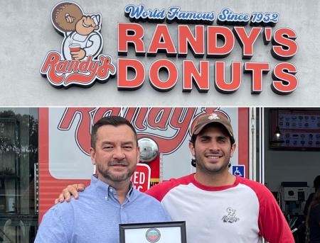 Clerk-Recorder Hugh Nguyen presenting a certificate of recognition to Randy's Donuts.