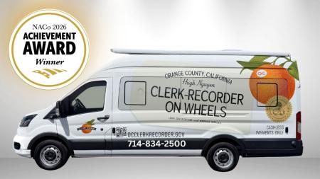 Naco Achievement Award Winner in White Circle in Top Left Corner with Golden Outline, White Van with an orange on the window with information about Clerk-Recorder on Wheels